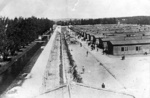 KL Dachau: general view of the prisoner barracks, high-voltage barbed-wire fence electrified at all times, KL Dachau prisoners next to the barracks. /April 1945/. (IPN)